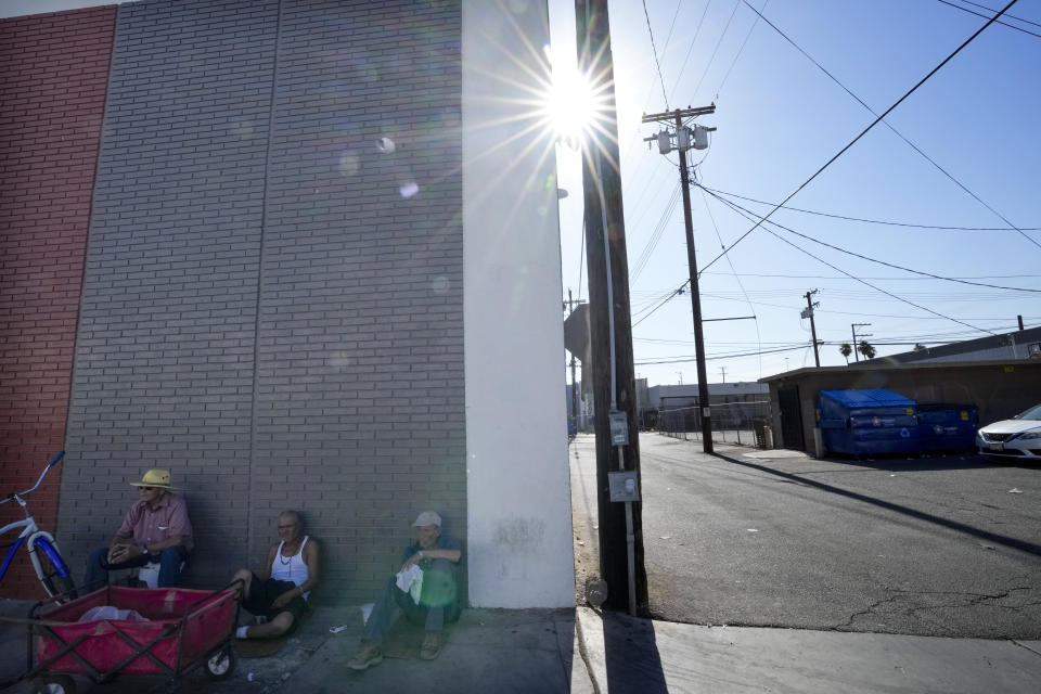 Men sit in the shade amid extreme heat on Wednesday, July 19, 2023, in Calexico, Calif. (AP Photo/Gregory Bull)