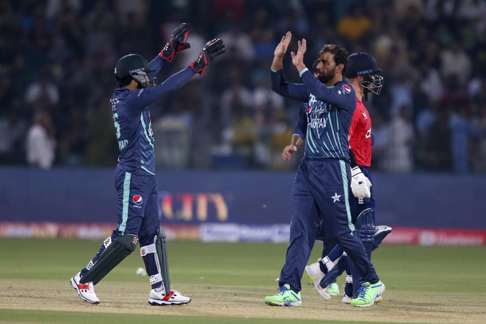 Pakistan's Mohammad Rizwan, left, celebrates with teammate after run out to England's Ben Duckett during the seventh twenty20 cricket match between Pakistan and England, in Lahore, Pakistan, Sunday, Oct. 2, 2022. (AP Photo/K.M. Chaudary)