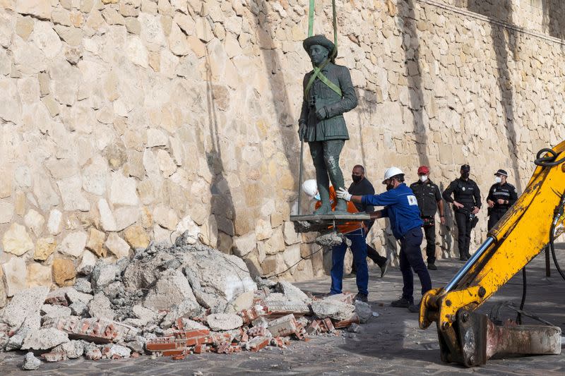 Local workers remove a statue of former Spanish dictator Francisco Franco in Spain