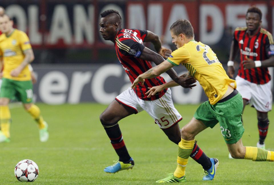 AC Milan's Mario Balotelli (L) and Celtic's Mikael Lustig fight for the ball during their Champions league Group H soccer match at San Siro stadium in Milan September 18, 2013. REUTERS/Alessandro Garofalo (ITALY - Tags: SPORT SOCCER)