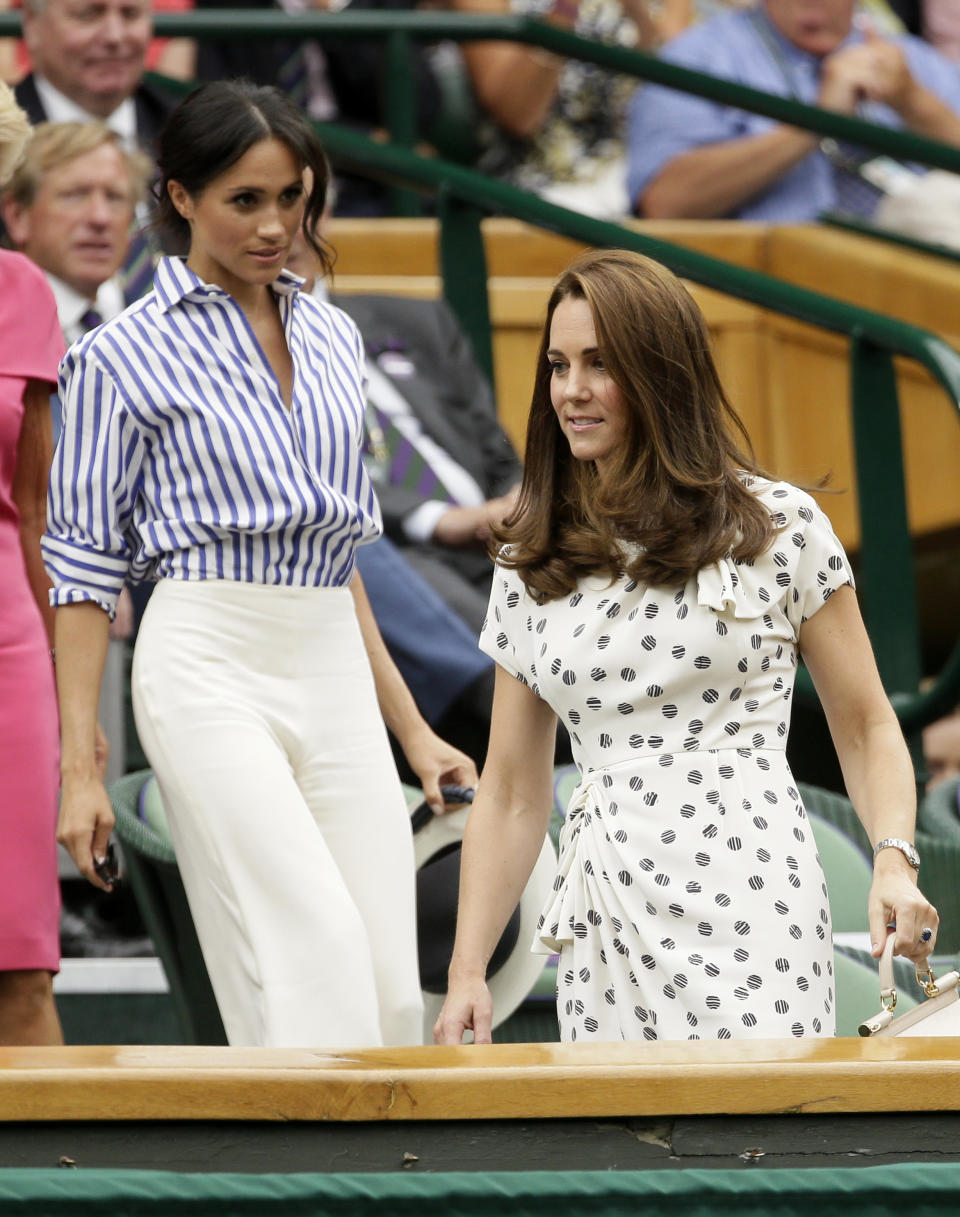 Kate, Duchess of Cambridge and Meghan, Duchess of Sussex, left, take their seats in the Royal Box on Centre Court at the Wimbledon on July 14.&nbsp;&nbsp; (Photo: ASSOCIATED PRESS)