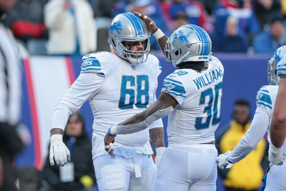 Nov 20, 2022; East Rutherford, New Jersey, USA; Detroit Lions running back Jamaal Williams (30) celebrates his rushing touchdown with offensive tackle Taylor Decker (68)  during the first half against the New York Giants at MetLife Stadium. Mandatory Credit: Vincent Carchietta-USA TODAY Sports