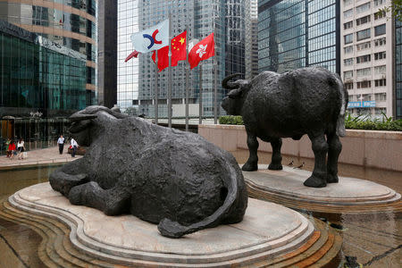 FILE PHOTO: (L-R) The Hong Kong Exchanges flag, Chinese national flag and Hong Kong flag are hoisted outside the Hong Kong Stocks Exchange in Hong Kong June 7, 2016. REUTERS/Bobby Yip/File Photo