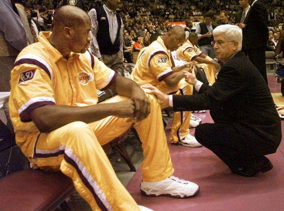 Los Angeles Lakers center Shaquille O'Neal, left, and Elden Campbell, center, listen to head coach Del Harris's instruction prior to the start of their season opener against the Phoenix Suns Friday, Nov. 1, 1996, in Inglewood, Calif.