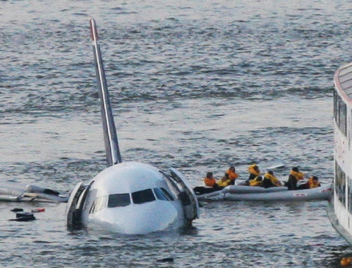 FILE - In this Jan. 15, 2009 file photo, passengers in an inflatable raft move away from US Airways Flight 1549 that went down in the Hudson River in New York. Capt. Chesley "Sully" Sullenberger III, First Officer Jeff Skiles and some passengers who were on the plane on Wednesday, Jan. 15, 2014 are expected to join some of the ferry crews who rescued them from the cold waters five years ago. (AP Photo/Bebeto Matthews, File)