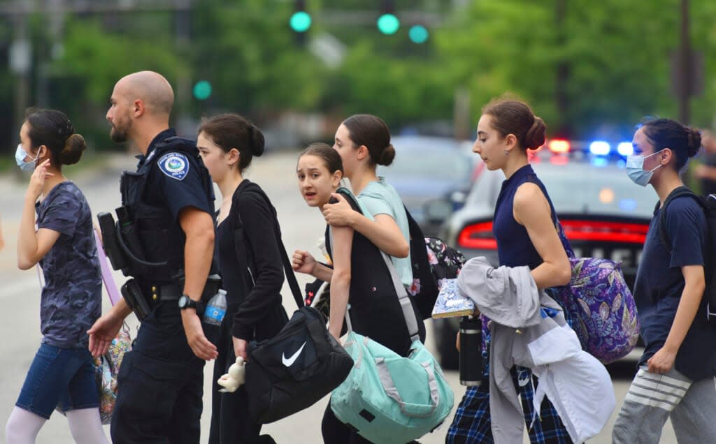 People are escorted away from the scene of a mass shooting on Monday, July 4, 2022 at a Fourth of July parade in Highland Park, Ill. (John Starks/Daily Herald via AP)