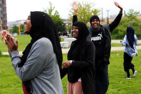 A group of women of Somali descent react as they play rounders in a park in Mjolnerparken, a housing estate that features on the Danish government's "Ghetto List", in Copenhagen, Denmark, May 12, 2018. REUTERS/Andrew Kelly