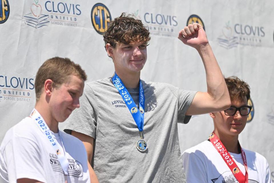 Loyola’s Rex Maurer raises his fist as he receives a medal for finishing first in the 500 freestyle at the CIF swimming and diving state championships on Saturday, May 13, 2023 in Fresno.