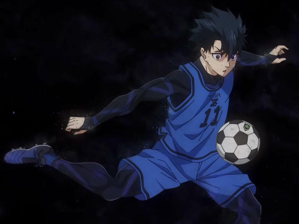 a young man with black hair focuses on a soccer ball, his right leg pulled back ready to kick it. it's from the anime blue lock, and the boy is also wearing a blue soccer jersey and shorts.