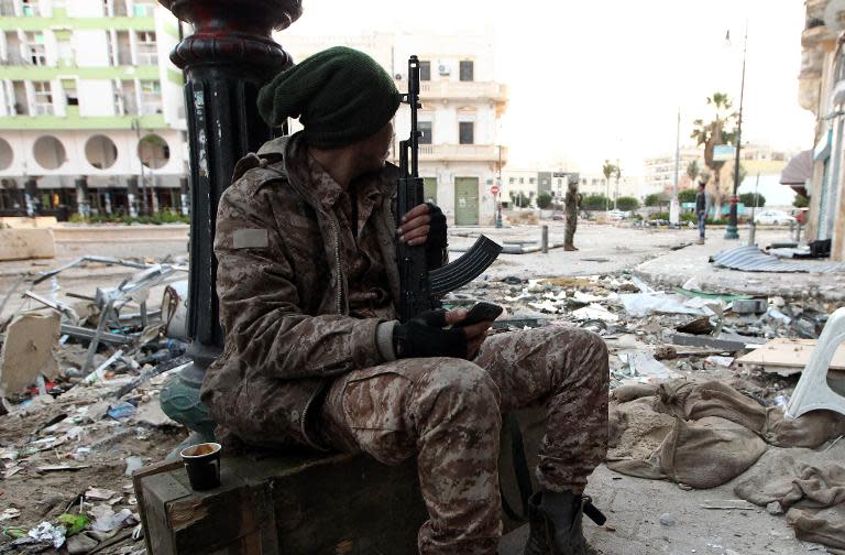 A Libyan soldier, loyal to the internationally recognised government, rests on a sidewalk in the eastern coastal city of Benghazi on February 28, 2015