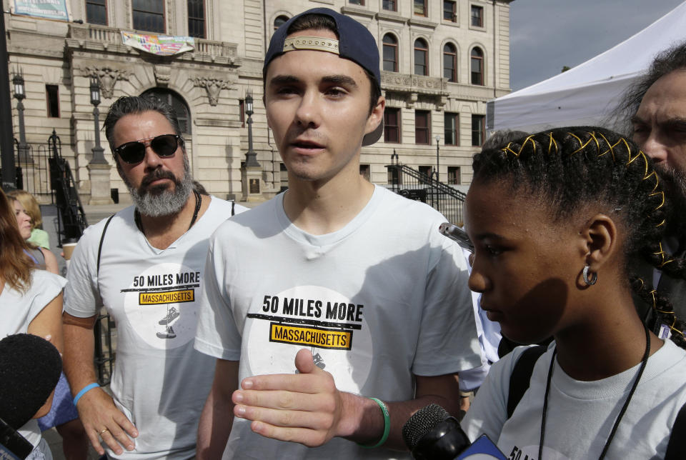 David Hogg, center, a survivor of the school shooting at Marjory Stoneman Douglas High School, in Parkland, Fla., speaks with reporters as Manuel Oliver, left, father of slain Marjory Stoneman Douglas student Joaquin Oliver, and Boston high school student Vikiana Petit-Homme, right, look on before the start of a planned 50-mile march, Thursday, Aug. 23, 2018, in Worcester, Mass. The march, held to call for gun law reforms, began Thursday, in Worcester, and is scheduled to end Sunday, Aug. 26, in Springfield, Mass., at the headquarters of gun manufacturer Smith & Wesson. (AP Photo/Steven Senne)