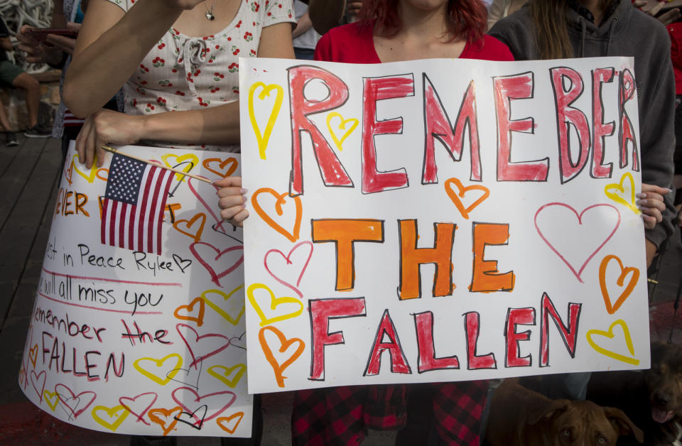 Jenna Christie, 17, and Emma Stone, 17, friends of Marine Lance Cpl. Rylee McCollum, show their support during his procession in Jackson, Wyo., on Friday, Sept. 10, 2021. McCollum was one of the service members killed in Afghanistan after a suicide bomber attacked Hamid Karzai International Airport on Aug. 26. (AP Photo/Amber Baesler)