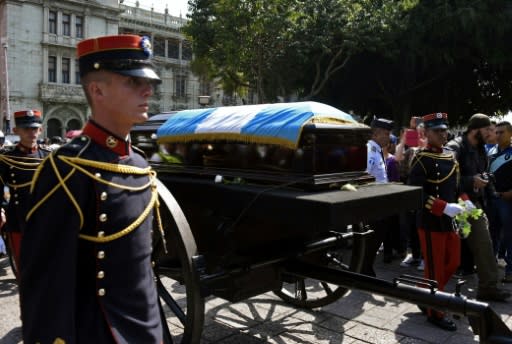 The brown wooden coffin carrying the remains of ex-president Alvaro Arzu, wrapped in the blue and white flag of Guatemala, was flanked by military officers as it made its way slowly from the National Palace of Culture to the Municipality building