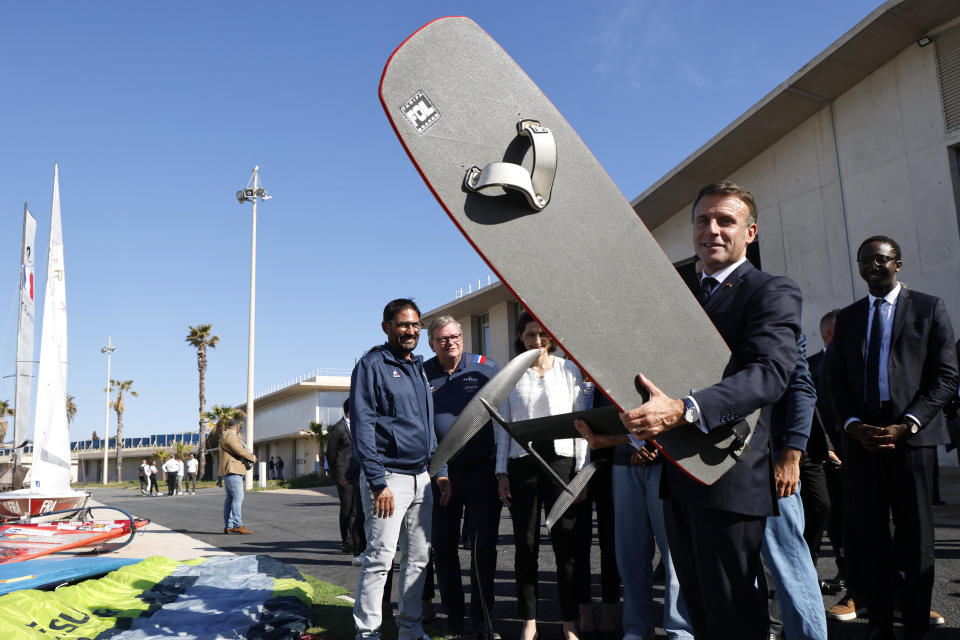 French President Emmanuel Macron holds a wingfoil board at the Marina Olympique nautical base in Marseille, France, May 8, 2024, ahead of the transfer of the Olympic flame to shore from a 19th-century tall ship to mark the start of a 7,500-mile torch relay across France and the country's far-flung territories. / Credit: Ludovic Marin/Pool/AFP via Getty Images