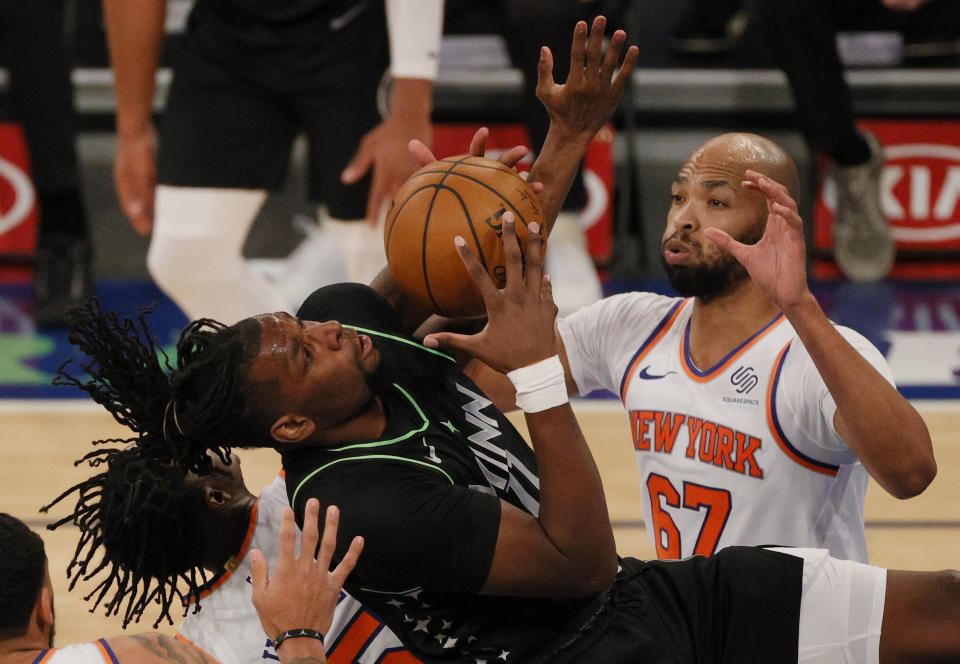 Naz Reid, left, of the Minnesota Timberwolves looks to shoot as Taj Gibson, right, of the New York Knicks defends during the first half of an NBA basketball game Sunday, Feb. 21, 2021, in New York. (Sarah Stier/Pool Photo via AP)