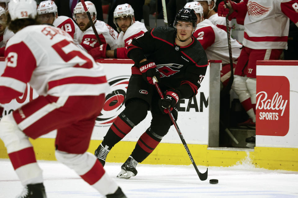 Carolina Hurricanes' Andrei Svechnikov (37) looks to pass the puck around Detroit Red Wings' Moritz Seider (53) during the second period of an NHL hockey game in Raleigh, N.C., Friday, Jan. 19, 2024. (AP Photo/Karl B DeBlaker)