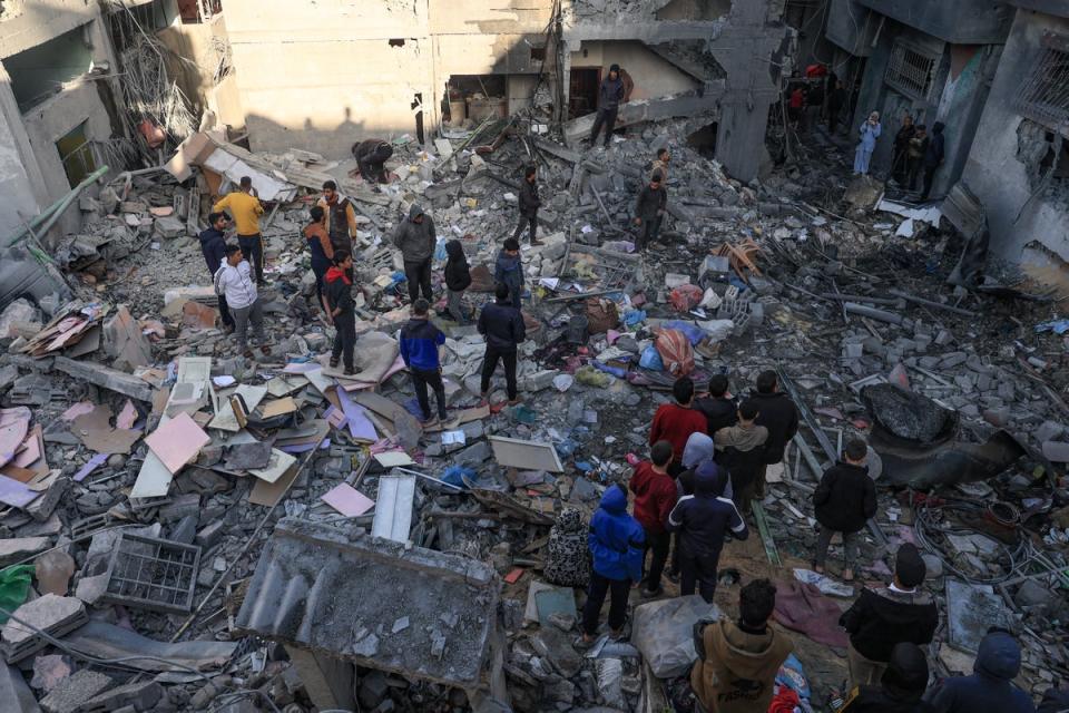 People gather amid the destruction following an early morning Israeli strike in Rafah in the southern Gaza Strip in December (AFP via Getty Images)