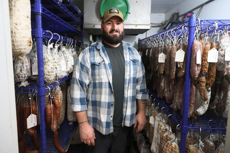 Charcutier Mitchell Marable stands inside Paradox Charcuterie&#39;s drying room amongst a variety of house-cured meats at their shop on Thursday, January 13, 2022. As Marable wryly describes his position, &quot;I&#39;m just a guy who throws salt at things and makes the edible.&quot;