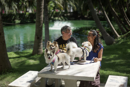 German Ralf Wacker and his wife Ploynisa Duangdararungrueng pose for photo with their dogs at a park near their house in Ayutthaya province, Thailand, August 22, 2017. REUTERS/Athit Perawongmetha