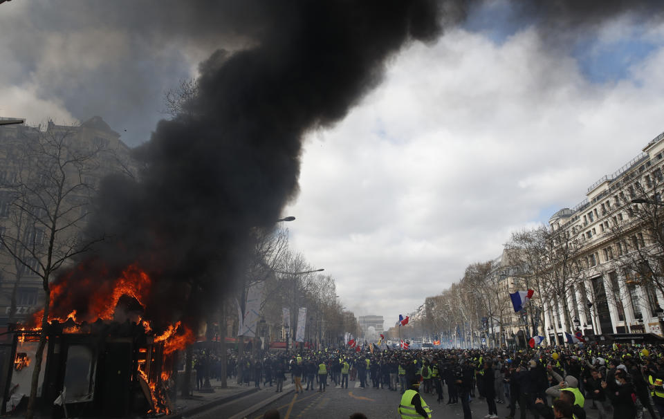 A news stand burns during a yellow vests demonstration on the Champs Elysees avenue Saturday, March 16, 2019 in Paris. French yellow vest protesters clashed Saturday with riot police near the Arc de Triomphe as they kicked off their 18th straight weekend of demonstrations against President Emmanuel Macron. (AP Photo/Christophe Ena)