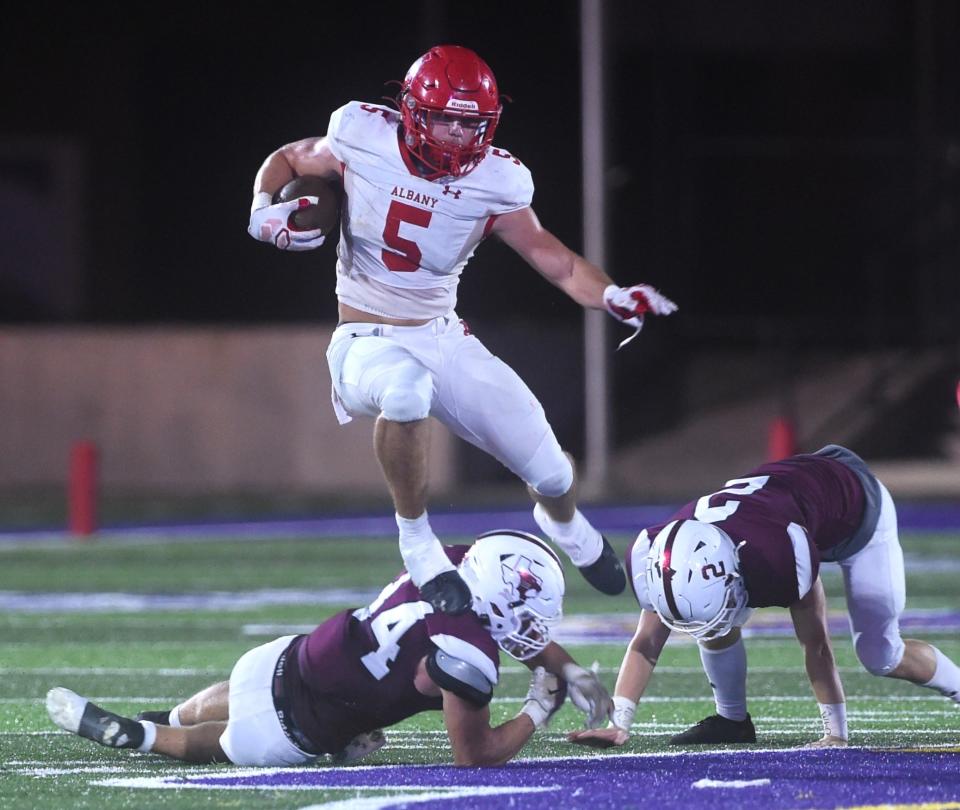 Albany running back Adam Hill (5) leaps over a Hawley defender. Albany beat the Bearcats 27-14 on Sept. 15 at Hardin-Simmons' Shelton Stadium in Abilene.