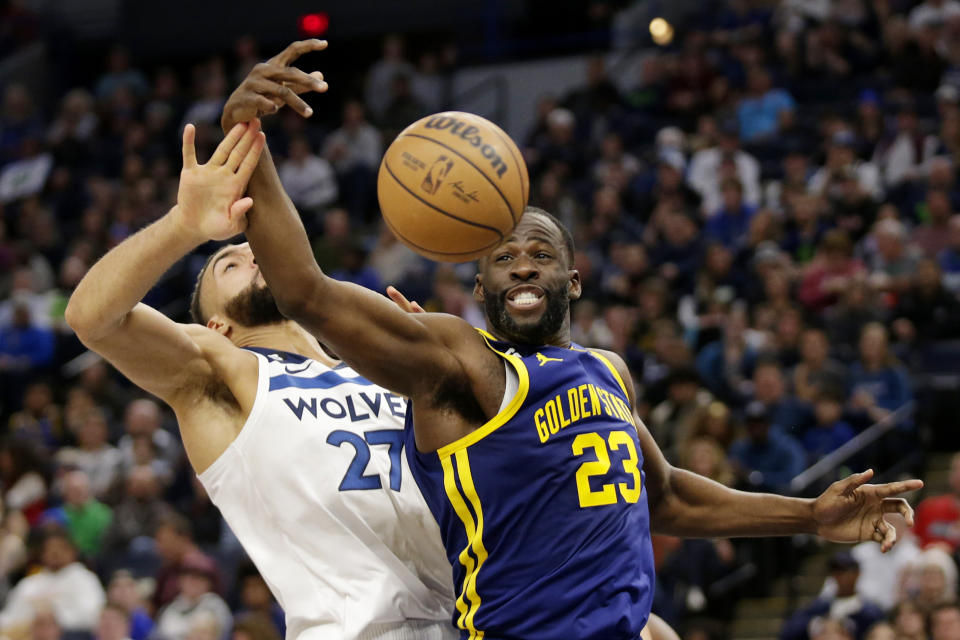 Golden State Warriors forward Draymond Green (23) and Minnesota Timberwolves center Rudy Gobert (27) vie for a rebound in the second quarter of an NBA basketball game Sunday, Nov. 27, 2022, in Minneapolis. (AP Photo/Andy Clayton-King)