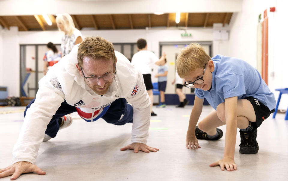 <p>Paralympics GB athlete Jody Cundy OBE and Tommy, Year 5 pupil, during a visit to Booker Park School to give them advice on how to get involved in Paralympic sports as part of Virgin Media's #WeAreHere campaign in Stoke Mandeville, the birthplace of the Paralympics. Issue date: Friday September 10, 2021.</p>
