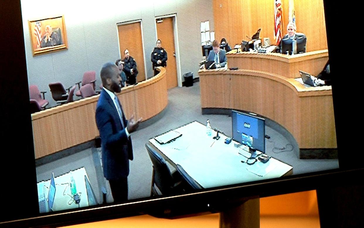 Thomas R. Carraher's defense attorney Emeka Nkwuo is shown on a monitor as he speaks to the court during his detention hearing before Superior Court Judge Paul X. Escandon in Freehold Monday, January 29, 2024. Carraher, a Tinton Falls elementary school teacher, is accused of trying to solicit sex from a minor.