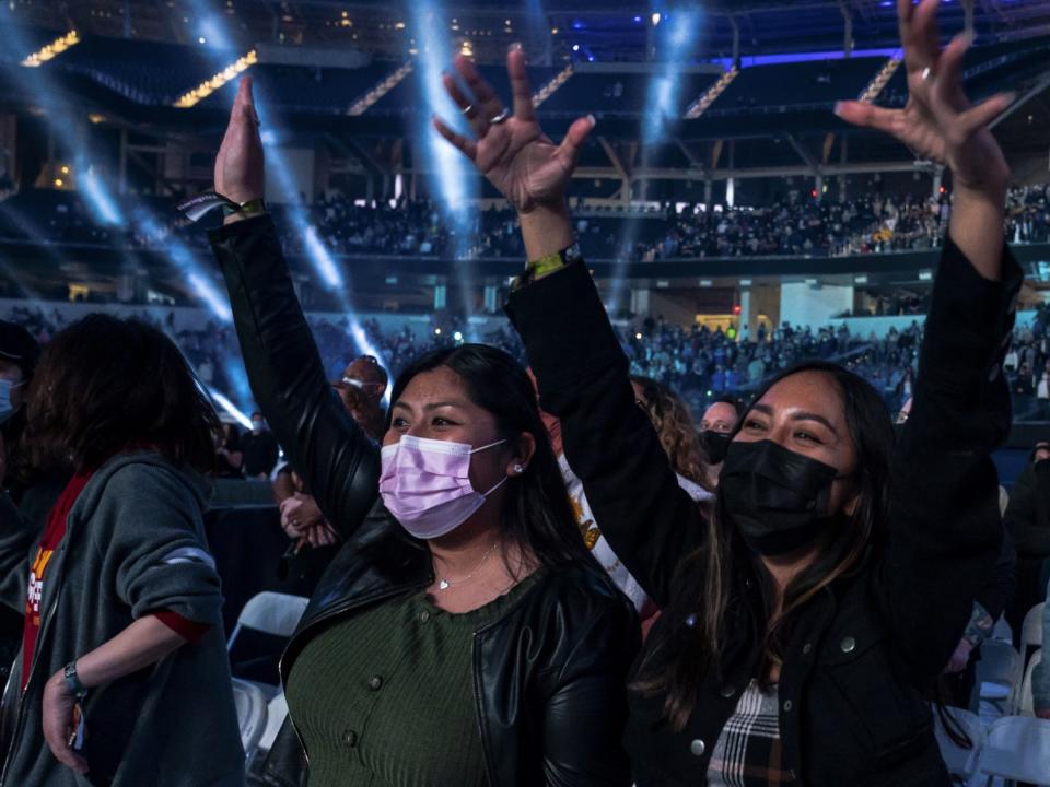 People lift their hands at the Vax Live concert