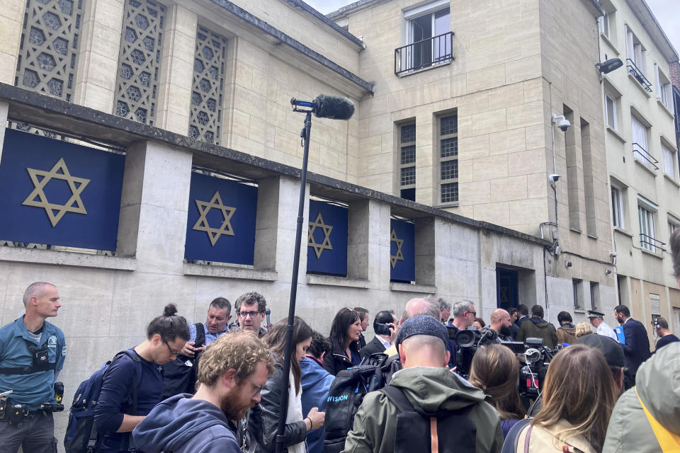 Journalists gather in front of the synagogue in Rouen, Friday, May 17, 2024. French police have shot and killed a man armed with a knife and a metal bar who is suspected of having set fire to a synagogue in the Normandy city of Rouen. French police said officers were alerted early Friday morning that smoke was rising from the synagogue and came face to face with the man when they got there. (AP Photo/Oleg Cetinic)