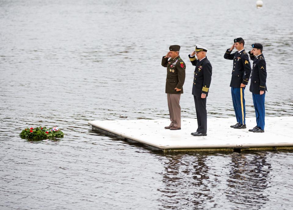 Retired Brig. Gen. Donald Bolduc, left, and Retired Navy Capt. John Dal Santo join a salute as a wreath honoring fallen soldiers is floated in the Squamscott River in Exeter on Memorial Day, Monday, May 31, 2021.