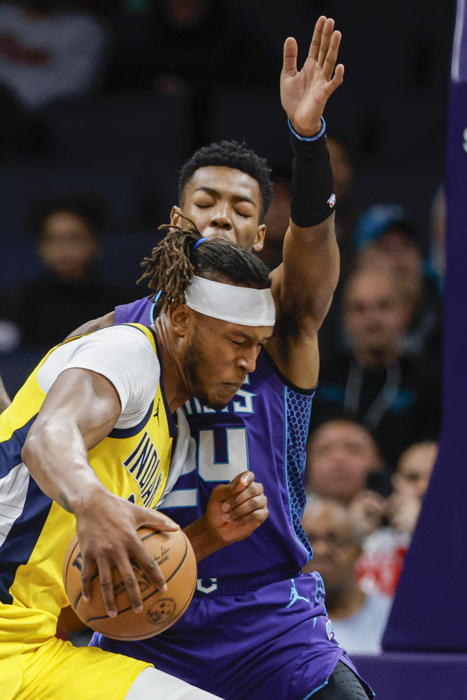 Indiana Pacers center Myles Turner, bottom, drives into Charlotte Hornets forward Brandon Miller, top, during the first half of an NBA basketball game in Charlotte, N.C., Monday, Feb. 12, 2024. (AP Photo/Nell Redmond)