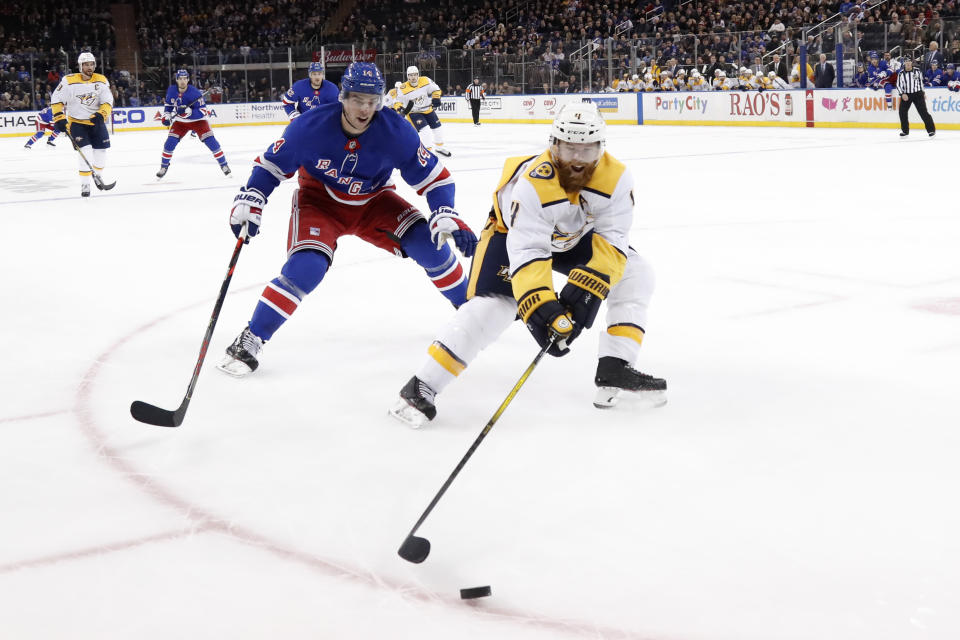 Nashville Predators defenseman Ryan Ellis (4) controls the puck in front of New York Rangers center Greg McKegg (14) during the second period of an NHL hockey game, Monday, Dec. 16, 2019, in New York. (AP Photo/Kathy Willens)