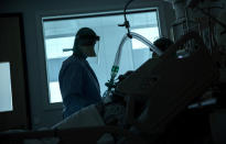 FILE - In this March 27, 2020, file photo, a health worker in the intensive care ward observes a COVID-19 patient at a hospital in Belgium. Experts say Europe has some of the world’s best health systems, but many hospitals have been overwhelmed with coronavirus patients and are ill-equipped to handle the pandemic. (AP Photo/Francisco Seco, File)