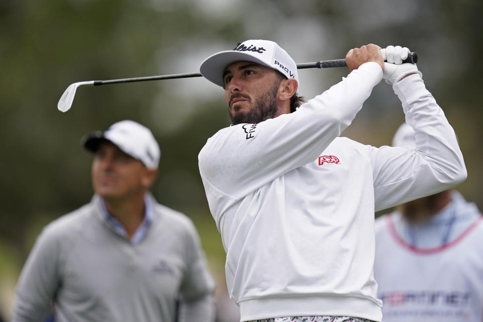 Max Homa follows his shot from the seventh tee of the Silverado Resort North Course during the final round of the Fortinet Championship PGA golf tournament in Napa, Calif., Sunday, Sept. 18, 2022. Justin Lower, left, looks on. (AP Photo/Eric Risberg)