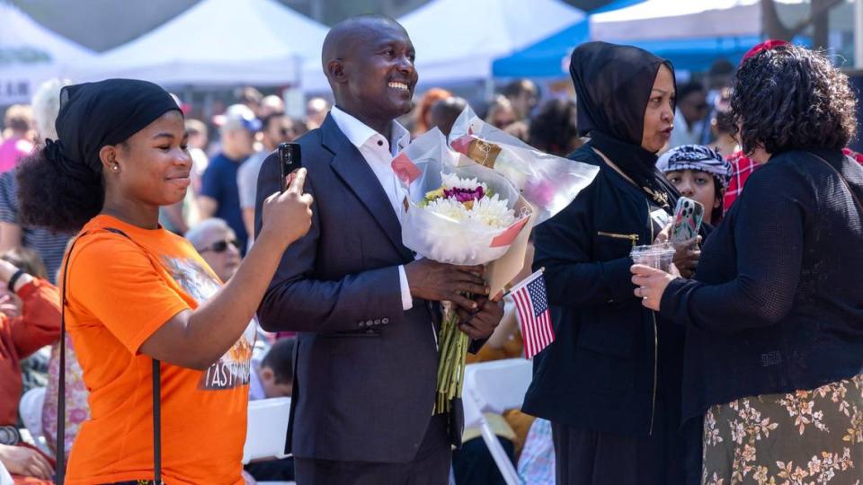 Uwantege Stratone from Burundi holds a bouquet of flowers after becoming an American citizen at a World Refugee Day celebration.