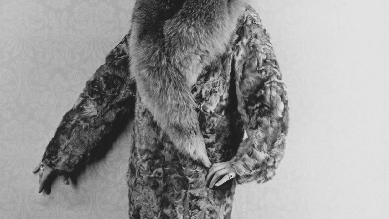 woman modeling lamb coat trimmed with fox