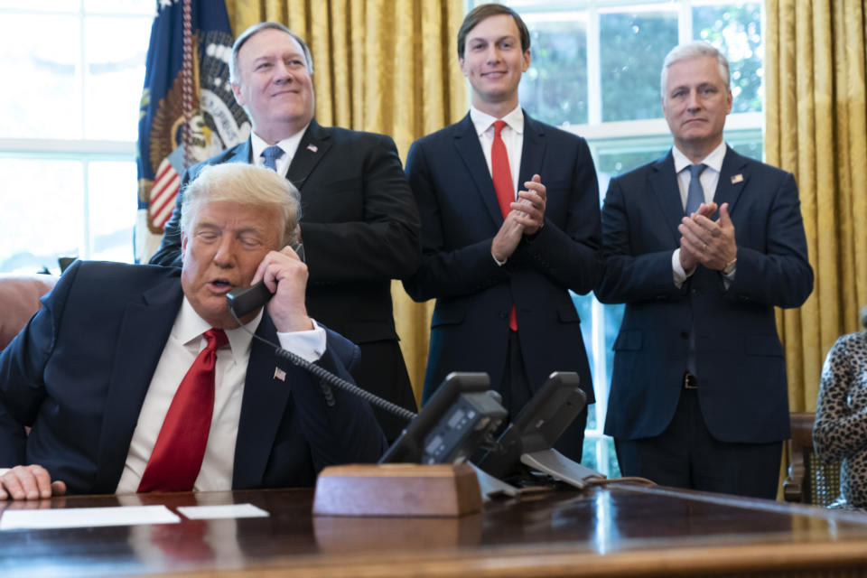 President Donald Trump talks on a phone call with the leaders of Sudan and Israel, as Secretary of State Mike Pompeo, left, White House senior adviser Jared Kushner, and National Security Adviser Robert O'Brien, applaud in the Oval Office of the White House, Friday, Oct. 23, 2020, in Washington. (AP Photo/Alex Brandon)