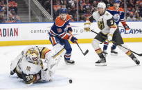 Vegas Golden Knights goalie Laurent Brossoit (39) makes a save as Edmonton Oilers' Zach Hyman (18) and Brayden McNabb (3) look for the rebound during the second period of an NHL hockey game Saturday, March 25, 2023, in Edmonton, Alberta. (Jason Franson/The Canadian Press via AP)