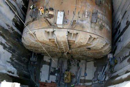 Workers make preparations to lift the cutting head from Bertha, the world's largest tunnel-boring machine, and lift it out for repairs in Seattle, Washington March 9, 2015. REUTERS/Jason Redmond/Files