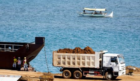 FILE PHOTO: A truck loads rocks and soil containing nickel-ore minerals into a barge in the mining town of Sta Cruz Zambales in northern Philippines February 8, 2017.    REUTERS/Erik De Castro/File Photo