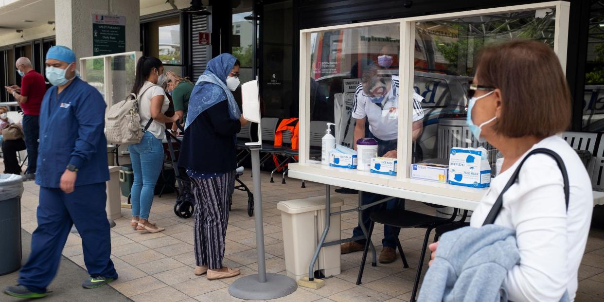 People wait for health assessment check in before entering Jackson Memorial Hospital, as Miami Dade County eases some of the lockdown measures put in place during the coronavirus disease (COVID 19) outbreak, in Miami, Florida, in June 2020..JPG