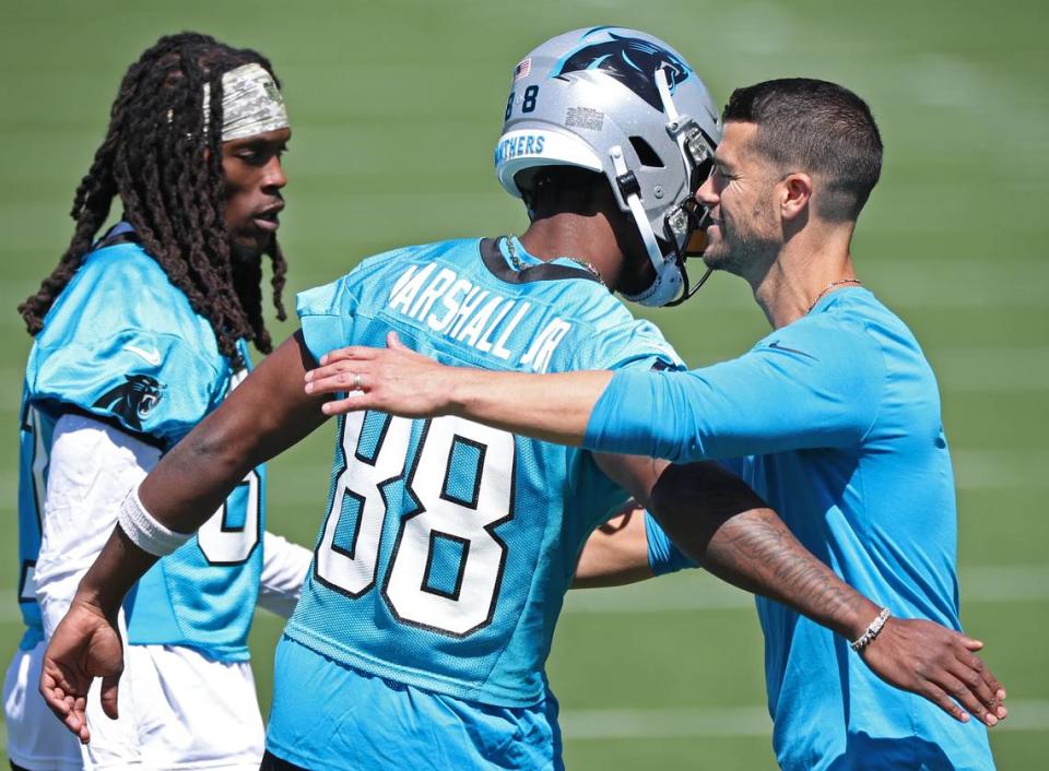 Carolina Panthers wide receiver Terrace Marshall, center, hugs head coach Dave Canales, right, during the team’s voluntary minicamp practice on Tuesday, April 23, 2024.