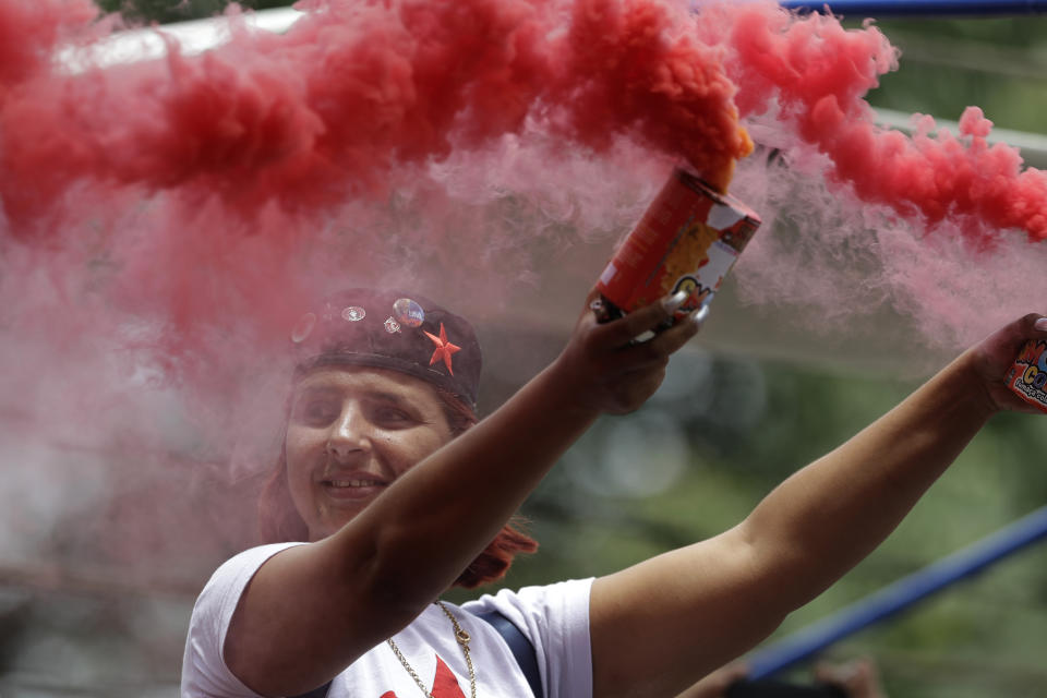 A supporter of Brazil's former President Luiz Inacio Lula da Silva waves colored smoke bombs in celebration during a rally at the Metal Workers Union headquarters, in Sao Bernardo, Brazil, Saturday, Nov. 9, 2019. Da Silva was released from jail Friday, less than a day after the Supreme Court ruled that a person can be imprisoned only after all the appeals have been exhausted. (AP Photo/Nelson Antoine)