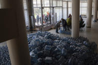 Local residents receive drinking water at a distribution centre in Toretsk, eastern Ukraine, Monday, April 25, 2022. Toretsk residents have had no access to water for more than two months because of the war. (AP Photo/Evgeniy Maloletka)