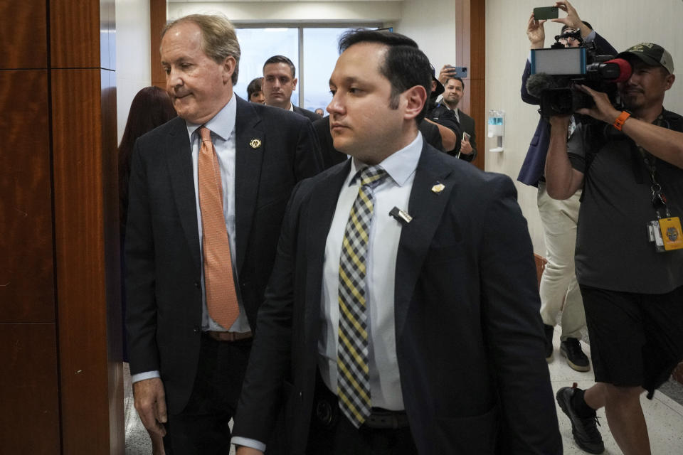 Texas Attorney General Ken Paxton, left, arrives to the 185th District Court for a hearing in his securities fraud case, Friday, Feb. 16, 2024, at the Harris County criminal courthouse in Houston. A judge on Friday rejected Paxton’s attempts to throw out felony securities fraud charges that have shadowed the Republican for nearly a decade. (Jon Shapley/Houston Chronicle via AP)