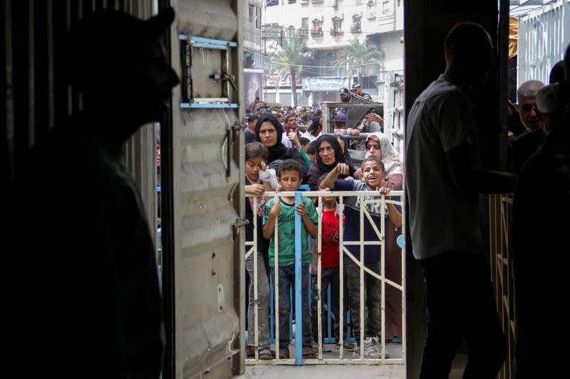 FILE PHOTO: Palestinians queue up to buy bread from a bakery in Gaza City