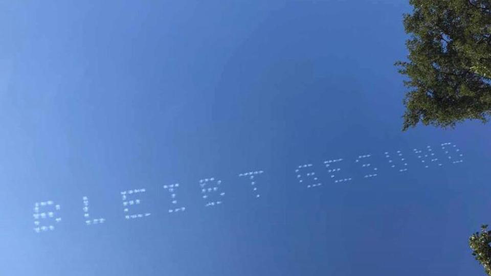 Der Schriftzug "Bleibt Gesund" am Himmel über München.