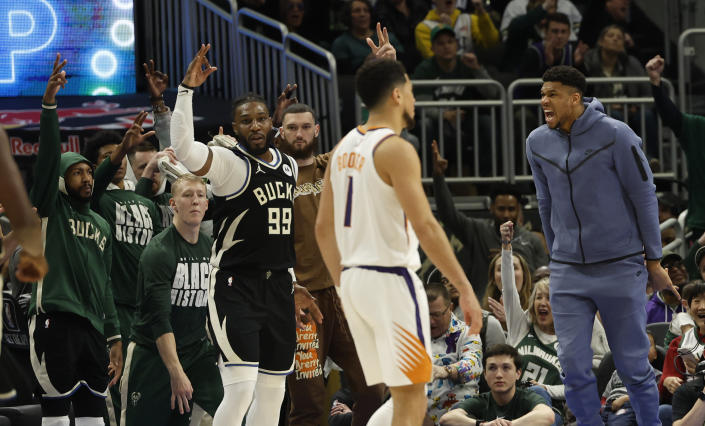 Milwaukee Bucks forward Giannis Antetokounmpo, right, reacts from the bench as Bucks forward Jae Crowder (99) hits a 3-point basket during the second half of an NBA basketball game against the Phoenix Suns, Sunday, Feb. 26, 2023, in Milwaukee. (AP Photo/Jeffrey Phelps)