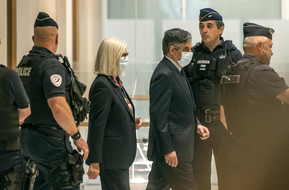 France's former Prime Minister Francois Fillon, right, and his wife Penelope wear protective masks as they arrive at Paris courthouse, in Paris, Monday, June 29, 2020. A Paris court is set to render or postpone a verdict in the fraud trial of former Prime Minister Francois Fillon on Monday. (AP Photo/Michel Euler)